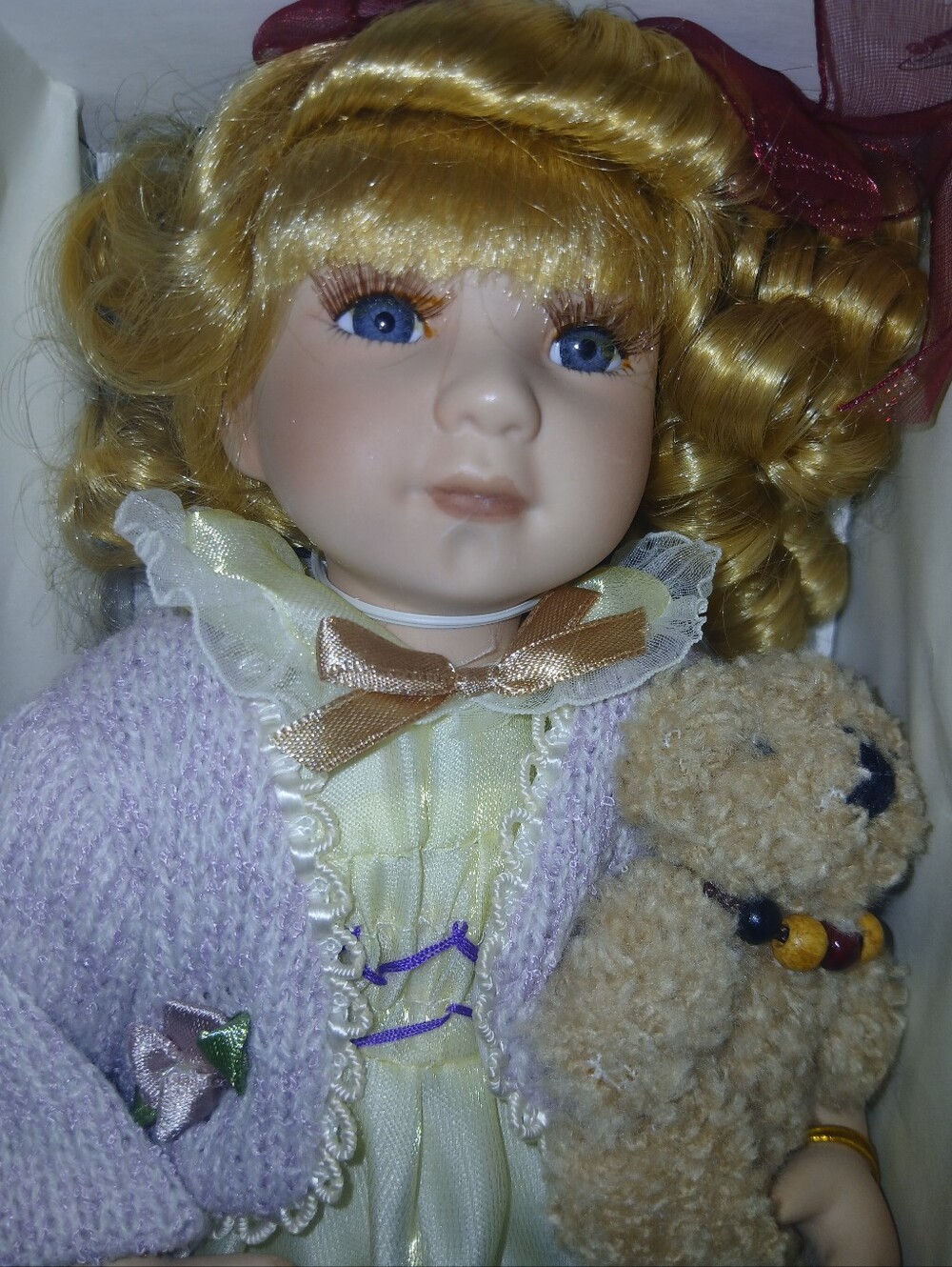Porcelain Doll with Blue Eyes and Blonde Hair in Lavender Sweater And Teddy Bear
